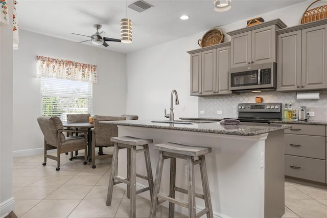 7750 Ridgelake Cir, Bradenton, FL 34203 - kitchen featuring stainless steel microwave, range with electric cooktop, gray cabinets, tasteful backsplash, and recessed lighting
