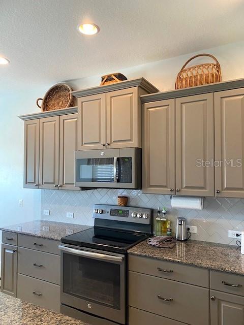 7750 Ridgelake Cir, Bradenton, FL 34203 - kitchen with stainless steel appliances, gray cabinets, and tasteful backsplash