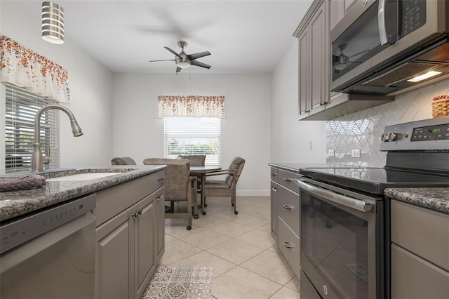 7750 Ridgelake Cir, Bradenton, FL 34203 - kitchen with stainless steel appliances, ceiling fan, tasteful backsplash, gray cabinetry, and light tile patterned floors