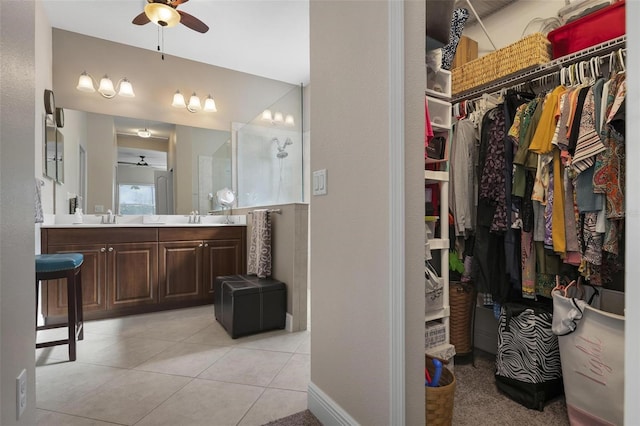 7750 Ridgelake Cir, Bradenton, FL 34203 - bathroom featuring a ceiling fan, vanity, a spacious closet, a walk in shower, and tile patterned floors