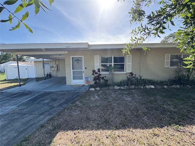 1224 38th St W, Bradenton, FL 34205 - ranch-style house with concrete block siding, a carport, concrete driveway, and a gate