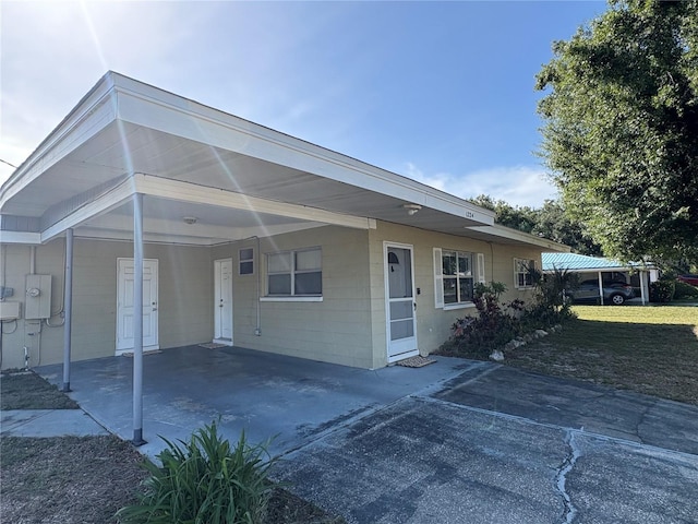 1224 38th St W, Bradenton, FL 34205 - back of property featuring a carport, concrete driveway, and concrete block siding