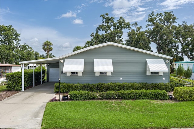 6710 36th Ave E Unit 114, Palmetto, FL 34221 - view of front of house featuring a front yard, concrete driveway, and an attached carport