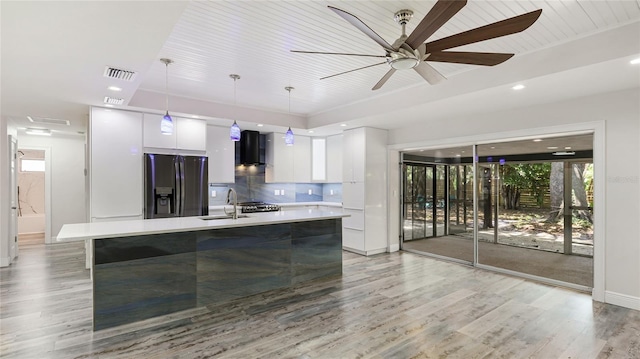 3525 Riviera Dr, Sarasota, FL 34232 - kitchen featuring fridge with ice dispenser, modern cabinets, light countertops, white cabinets, and light wood-type flooring