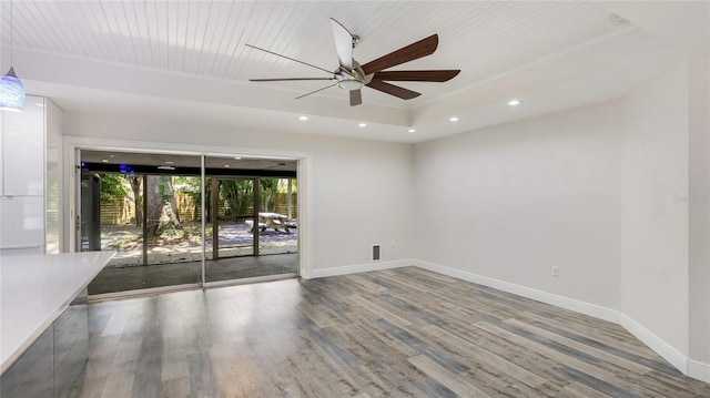 3525 Riviera Dr, Sarasota, FL 34232 - spare room with wood finished floors, ceiling fan, a tray ceiling, and recessed lighting