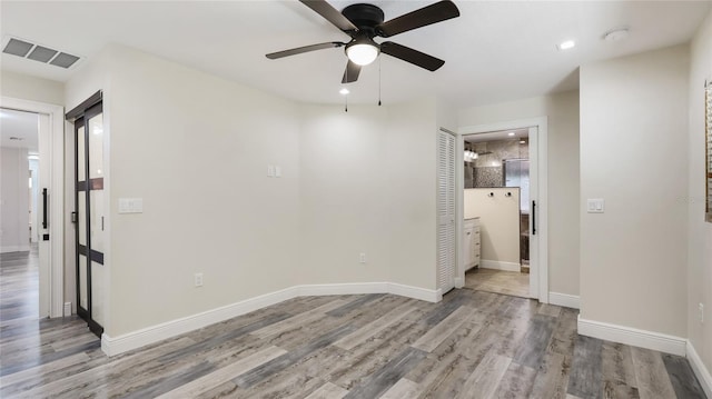 3525 Riviera Dr, Sarasota, FL 34232 - spare room with ceiling fan, wood finished floors, a smoke detector, and recessed lighting