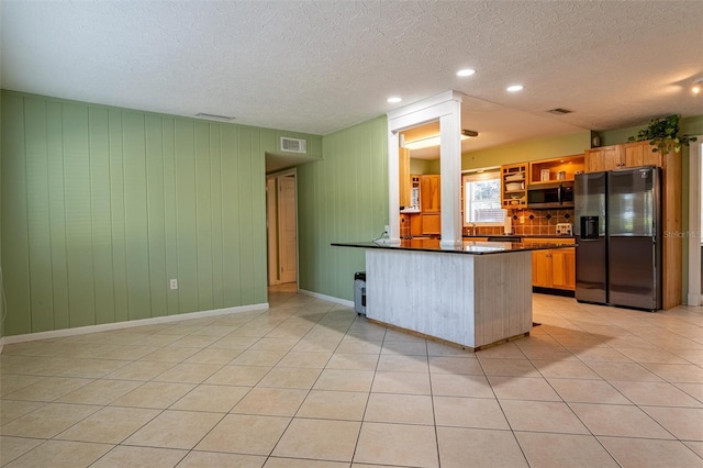 5311 36th Ave E, Palmetto, FL 34221 - kitchen with refrigerator with ice dispenser, stainless steel microwave, dark countertops, a peninsula, and light tile patterned floors