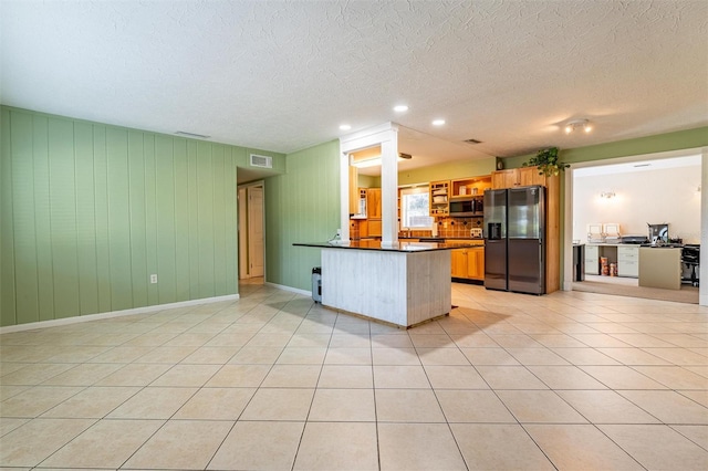 5311 36th Ave E, Palmetto, FL 34221 - kitchen with refrigerator with ice dispenser, dark countertops, stainless steel microwave, a peninsula, and light tile patterned flooring