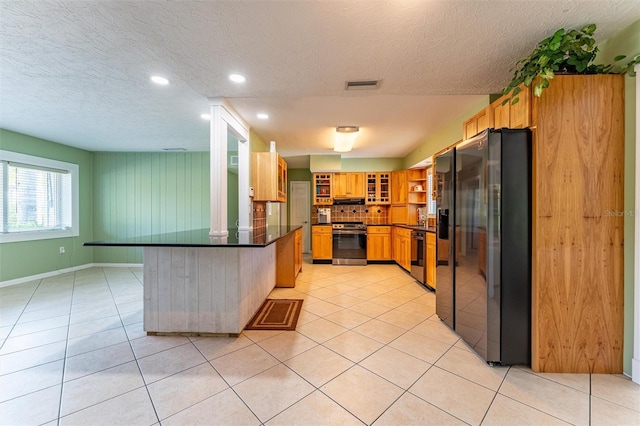 5311 36th Ave E, Palmetto, FL 34221 - kitchen with fridge with ice dispenser, stainless steel stove, dark countertops, a peninsula, and a textured ceiling