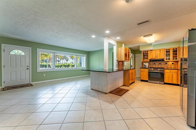 5311 36th Ave E, Palmetto, FL 34221 - kitchen with stainless steel range with electric stovetop, dark countertops, a textured ceiling, light tile patterned floors, and recessed lighting