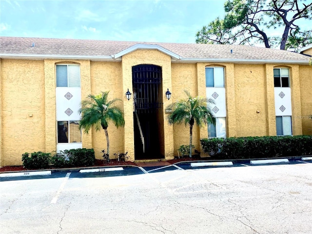 1959 Toucan Way Unit 206, Sarasota, FL 34232 - property entrance with uncovered parking, stucco siding, and roof with shingles