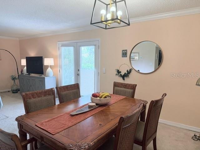1959 Toucan Way Unit 206, Sarasota, FL 34232 - dining space featuring light colored carpet, french doors, a chandelier, ornamental molding, and a textured ceiling