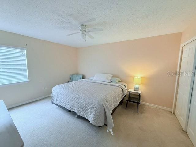1959 Toucan Way Unit 206, Sarasota, FL 34232 - bedroom with light colored carpet, a textured ceiling, and ceiling fan