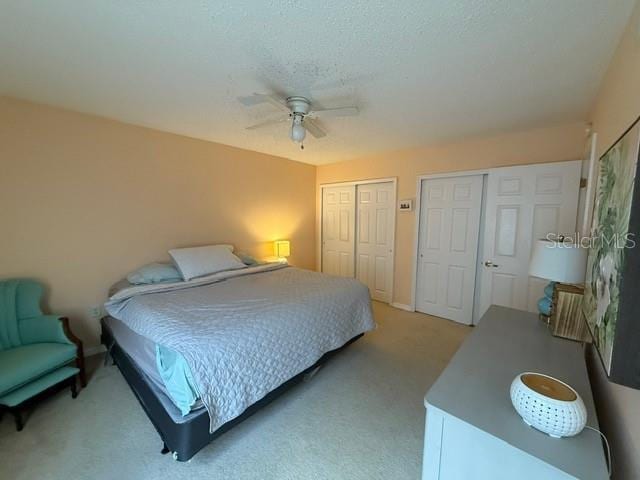 1959 Toucan Way Unit 206, Sarasota, FL 34232 - bedroom with multiple closets, light carpet, and a ceiling fan