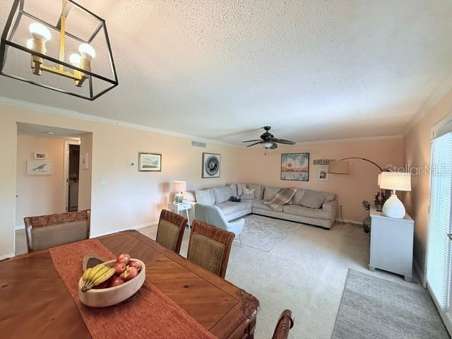 1959 Toucan Way Unit 206, Sarasota, FL 34232 - dining space featuring crown molding, a ceiling fan, healthy amount of natural light, and a textured ceiling