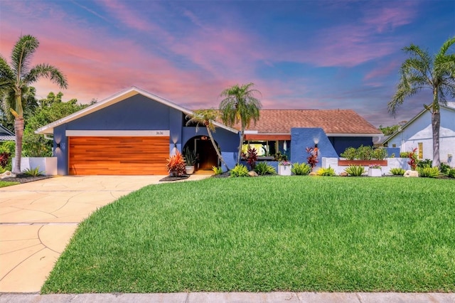 3636 Torrey Pines Blvd, Sarasota, FL 34238 - view of front of property featuring stucco siding, a garage, driveway, and a yard