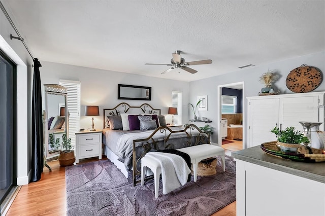 3636 Torrey Pines Blvd, Sarasota, FL 34238 - bedroom with light wood-style flooring, a textured ceiling, ensuite bathroom, and a ceiling fan