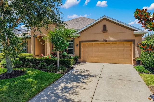 773 Rosemary Cir, Bradenton, FL 34212 - view of front of house featuring stucco siding, a garage, driveway, and a front lawn