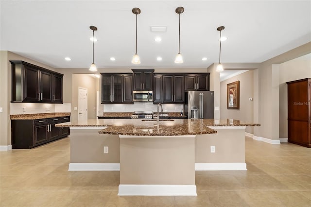 773 Rosemary Cir, Bradenton, FL 34212 - kitchen featuring appliances with stainless steel finishes, a large island, dark stone countertops, dark brown cabinets, and recessed lighting