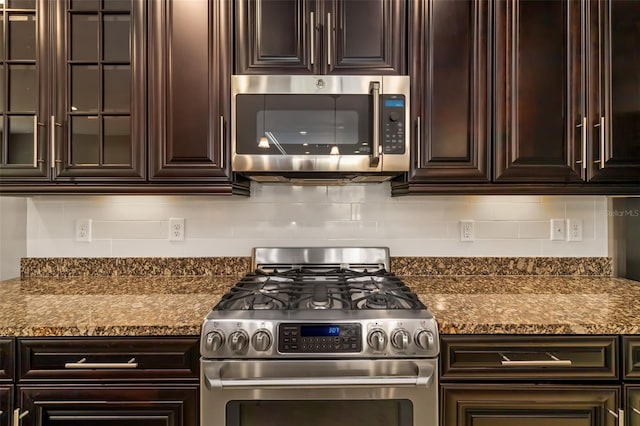 773 Rosemary Cir, Bradenton, FL 34212 - kitchen with stainless steel appliances, dark brown cabinetry, backsplash, and glass insert cabinets