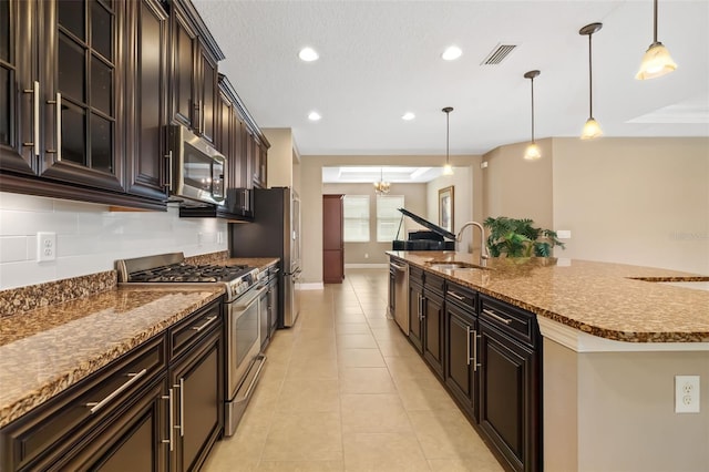 773 Rosemary Cir, Bradenton, FL 34212 - kitchen with stainless steel appliances, a kitchen island with sink, glass insert cabinets, pendant lighting, and light tile patterned floors
