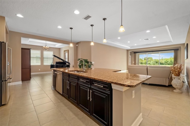 773 Rosemary Cir, Bradenton, FL 34212 - kitchen featuring a tray ceiling, stainless steel appliances, stone countertops, a center island with sink, and light tile patterned floors