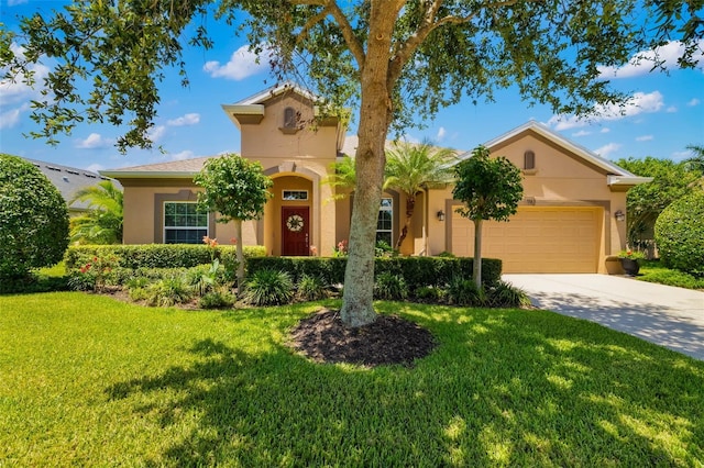 773 Rosemary Cir, Bradenton, FL 34212 - mediterranean / spanish home featuring stucco siding, an attached garage, a front lawn, and driveway