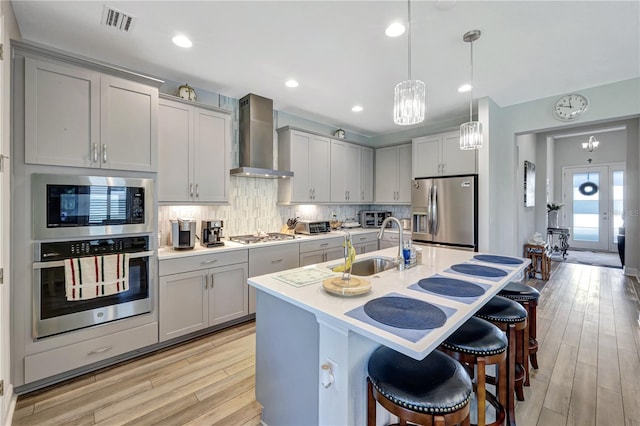 6219 Golden Nettle Dr, Apollo Beach, FL 33572 - kitchen featuring stainless steel appliances, wall chimney exhaust hood, gray cabinetry, light countertops, and recessed lighting