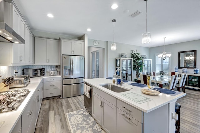 6219 Golden Nettle Dr, Apollo Beach, FL 33572 - kitchen featuring stainless steel appliances, wall chimney range hood, beverage cooler, light wood-style flooring, and gray cabinetry