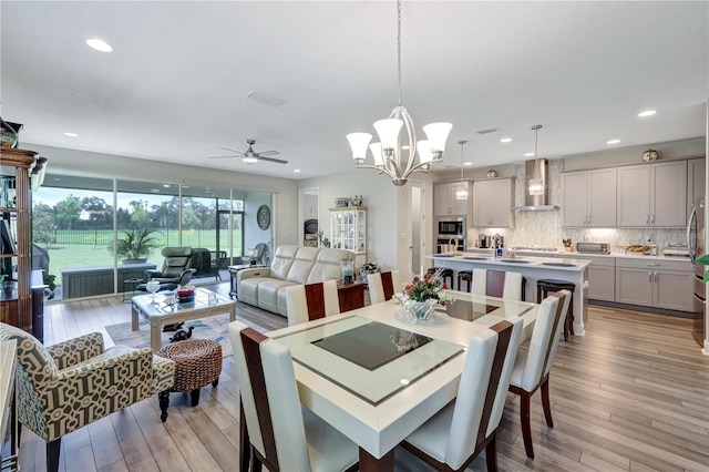 6219 Golden Nettle Dr, Apollo Beach, FL 33572 - dining area featuring light wood finished floors, ceiling fan, recessed lighting, and a chandelier