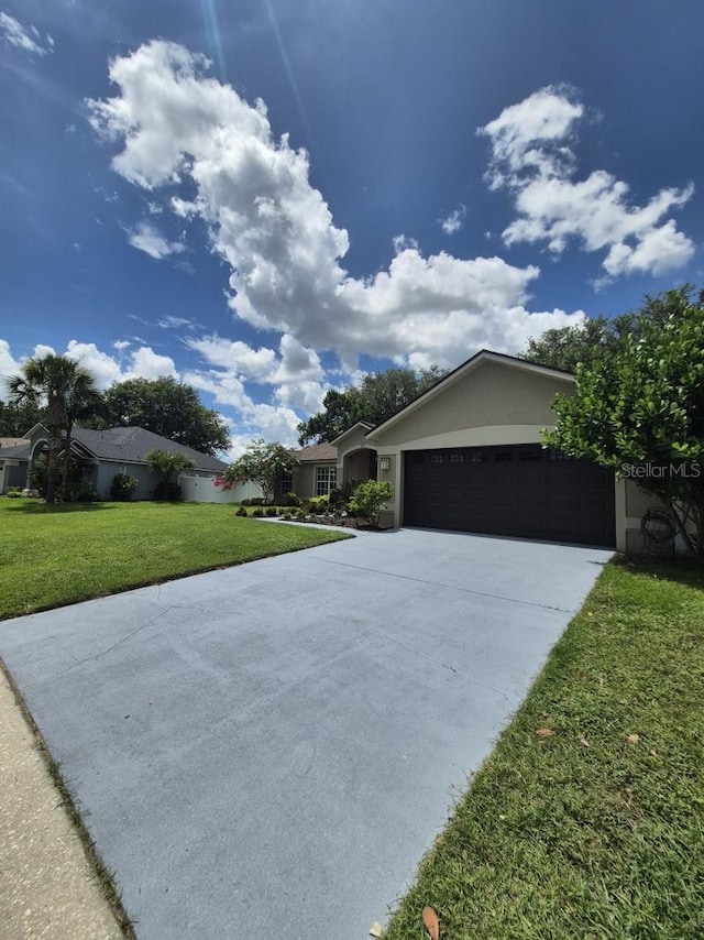 15917 Mercott Ct, Clermont, FL 34714 - view of front of home featuring driveway, a front yard, a garage, and stucco siding