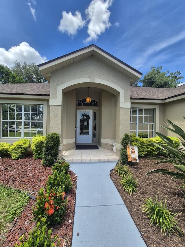 15917 Mercott Ct, Clermont, FL 34714 - doorway to property featuring stucco siding and a shingled roof