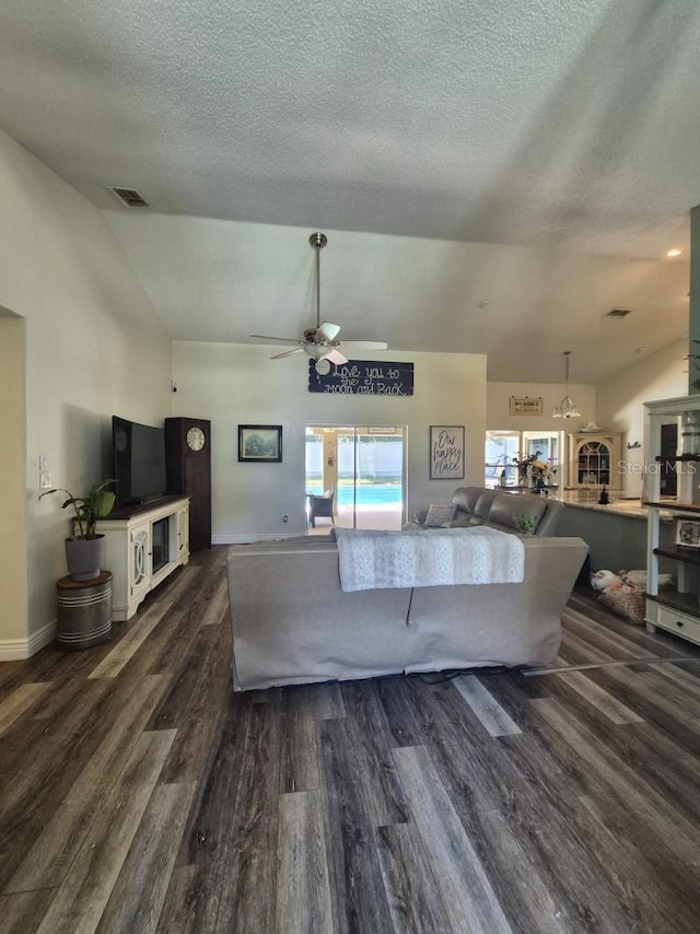 15917 Mercott Ct, Clermont, FL 34714 - living room with vaulted ceiling, dark wood-style flooring, ceiling fan, and a textured ceiling