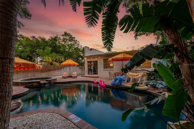 522 31st St W, Bradenton, FL 34205 - pool at dusk with a fenced backyard, a patio area, and a pool with connected hot tub
