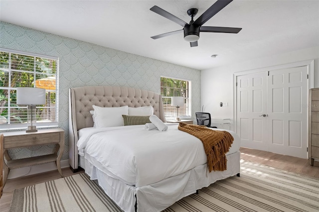 522 31st St W, Bradenton, FL 34205 - bedroom with wallpapered walls, an accent wall, light wood-style floors, a closet, and ceiling fan