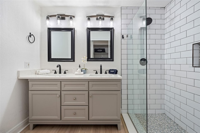 522 31st St W, Bradenton, FL 34205 - bathroom featuring a walk in shower, double vanity, and wood finished floors