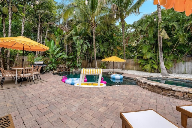 522 31st St W, Bradenton, FL 34205 - fenced backyard with an in-ground hot tub, a patio, and outdoor dining area