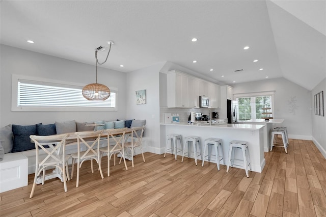 538 Canal Rd, Sarasota, FL 34242 - kitchen featuring stainless steel appliances, a kitchen breakfast bar, a peninsula, breakfast area, and light wood-style flooring
