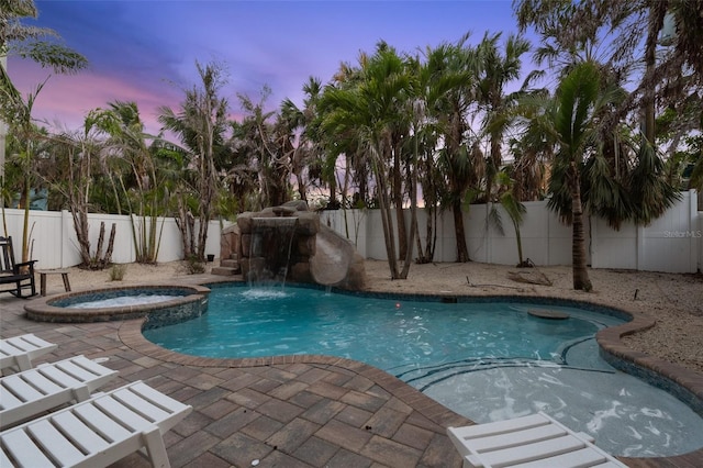 538 Canal Rd, Sarasota, FL 34242 - pool at dusk featuring a fenced backyard, a patio, and a pool with connected hot tub