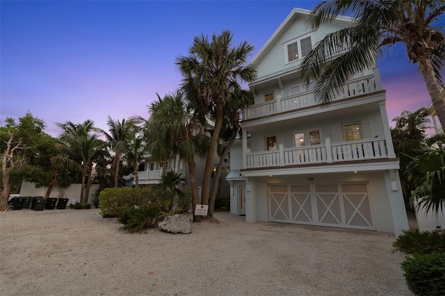 538 Canal Rd, Sarasota, FL 34242 - raised beach house with a balcony, an attached garage, driveway, and stucco siding
