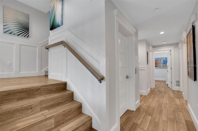 538 Canal Rd, Sarasota, FL 34242 - stairway with a decorative wall, wood finished floors, recessed lighting, and a wainscoted wall