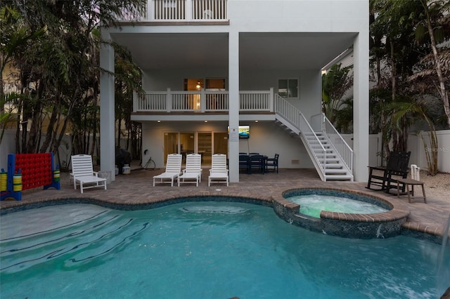 538 Canal Rd, Sarasota, FL 34242 - rear view of property with stairway, a patio area, a pool with connected hot tub, a balcony, and stucco siding