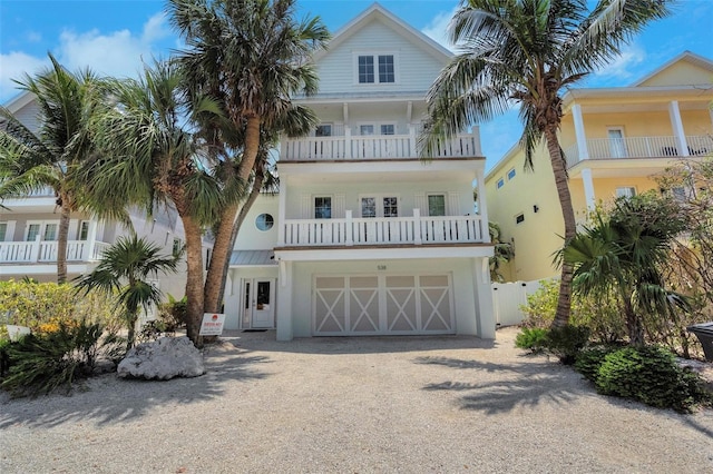 538 Canal Rd, Sarasota, FL 34242 - raised beach house featuring dirt driveway, a balcony, an attached garage, and stucco siding