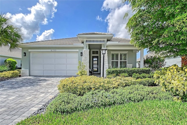 7983 Sandstar Way, Sarasota, FL 34240 - view of front of house with a tiled roof, stucco siding, a garage, and decorative driveway