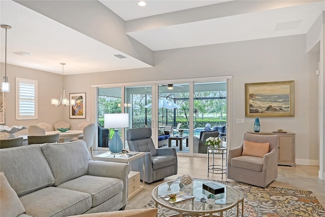 7983 Sandstar Way, Sarasota, FL 34240 - living room featuring healthy amount of natural light, light tile patterned floors, and a chandelier