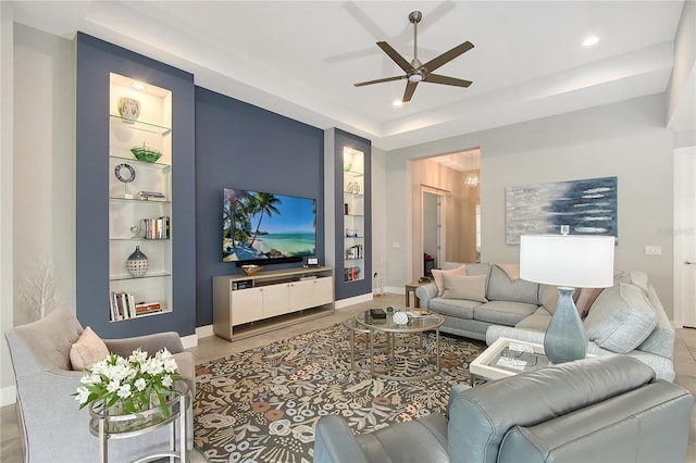 7983 Sandstar Way, Sarasota, FL 34240 - living room featuring built in shelves, a ceiling fan, recessed lighting, and a raised ceiling