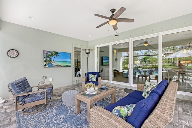 7983 Sandstar Way, Sarasota, FL 34240 - living area with ceiling fan, a sunroom, and stone tile flooring