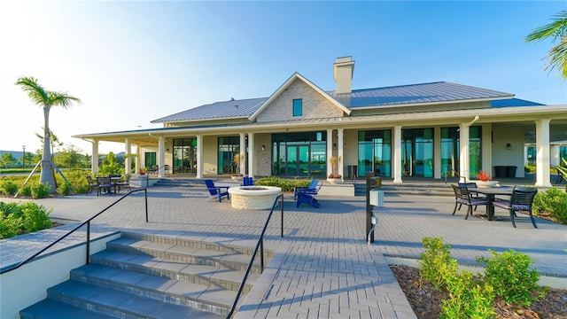 7983 Sandstar Way, Sarasota, FL 34240 - rear view of house featuring a chimney, a patio area, a metal roof, and a standing seam roof