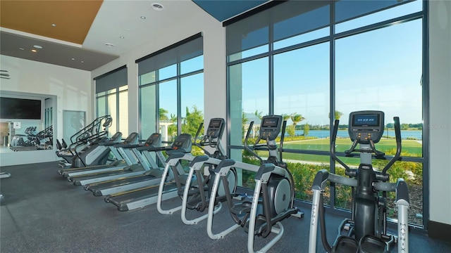 7983 Sandstar Way, Sarasota, FL 34240 - gym featuring a water view, a high ceiling, and recessed lighting