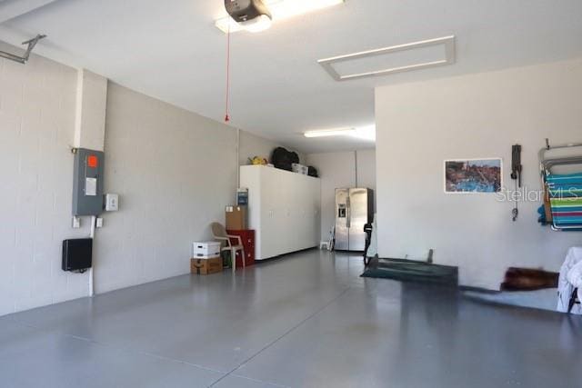 7983 Sandstar Way, Sarasota, FL 34240 - garage with stainless steel refrigerator with ice dispenser and electric panel